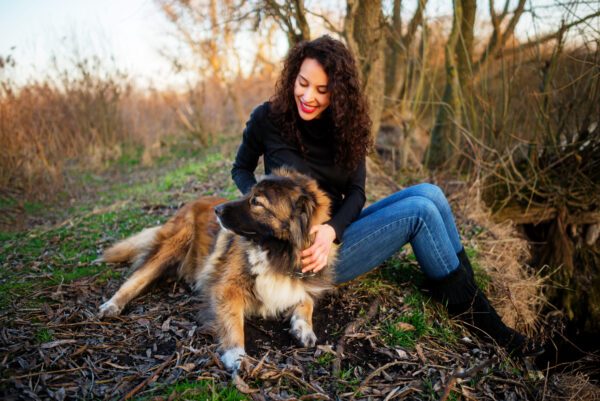 Caucasian Shepherd Dog With Woman Sitting Outdoors