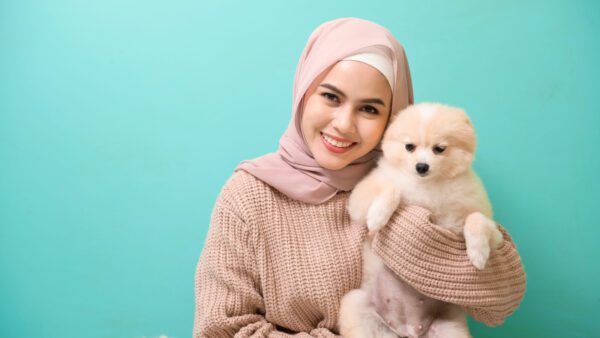 Pomapoo Puppy Being Held By Smiling Woman