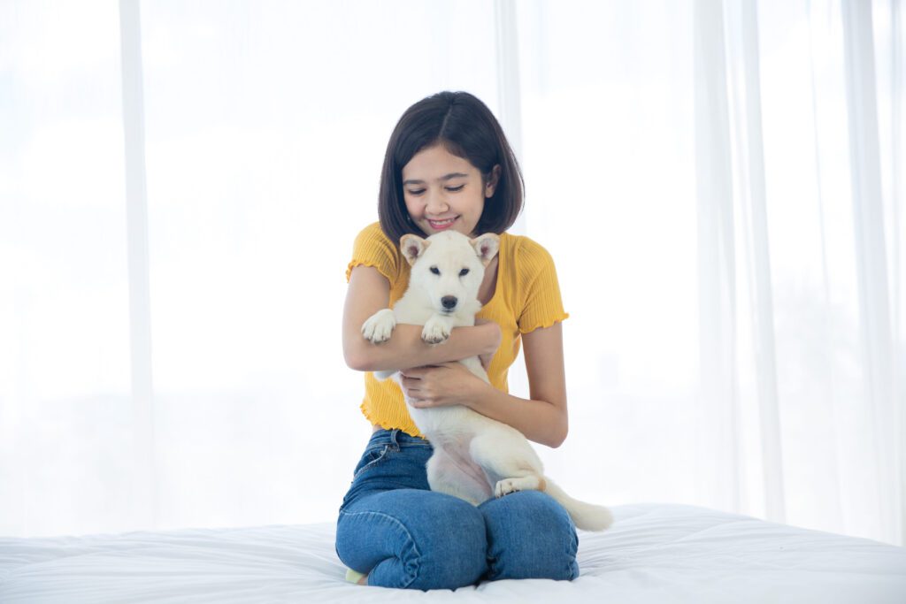 Woman Holding A Small Hokkaido Puppy Indoors