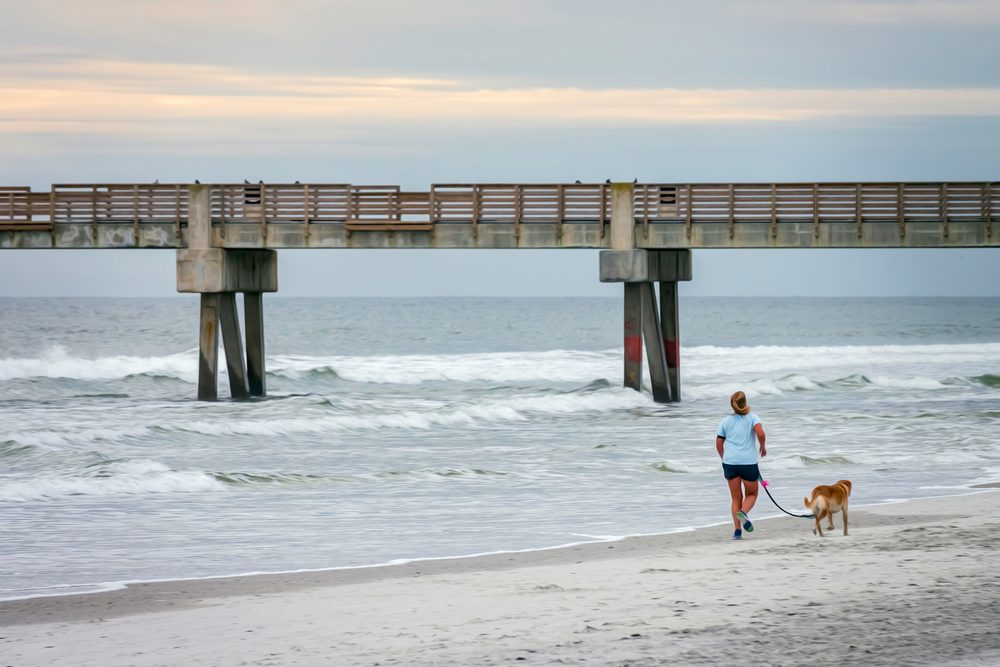 Woman and dog jog on Jacksonville Beach