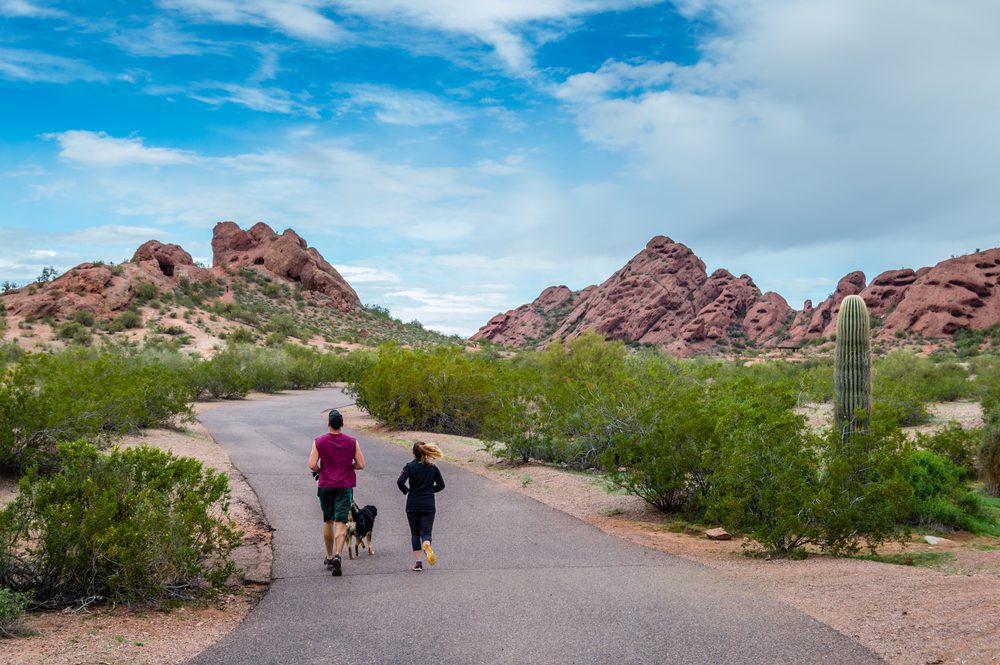 Two women jogging with a dog in Papago park, Phoenix
