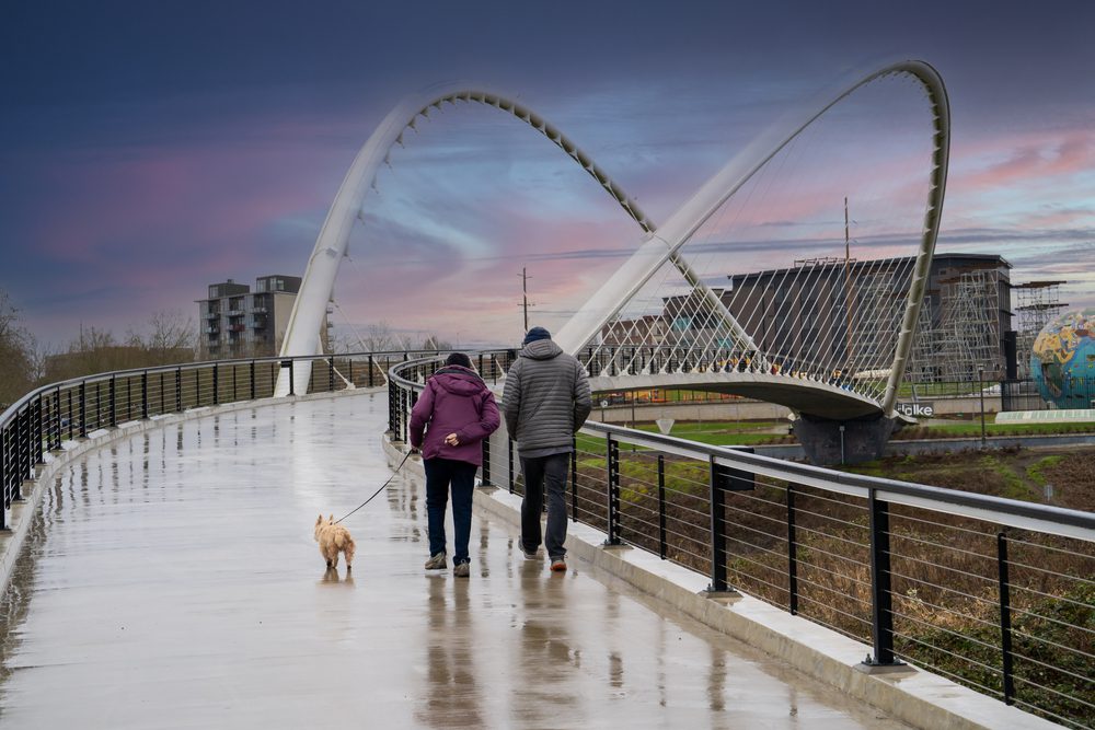 walking a dog across pedestrian bridge