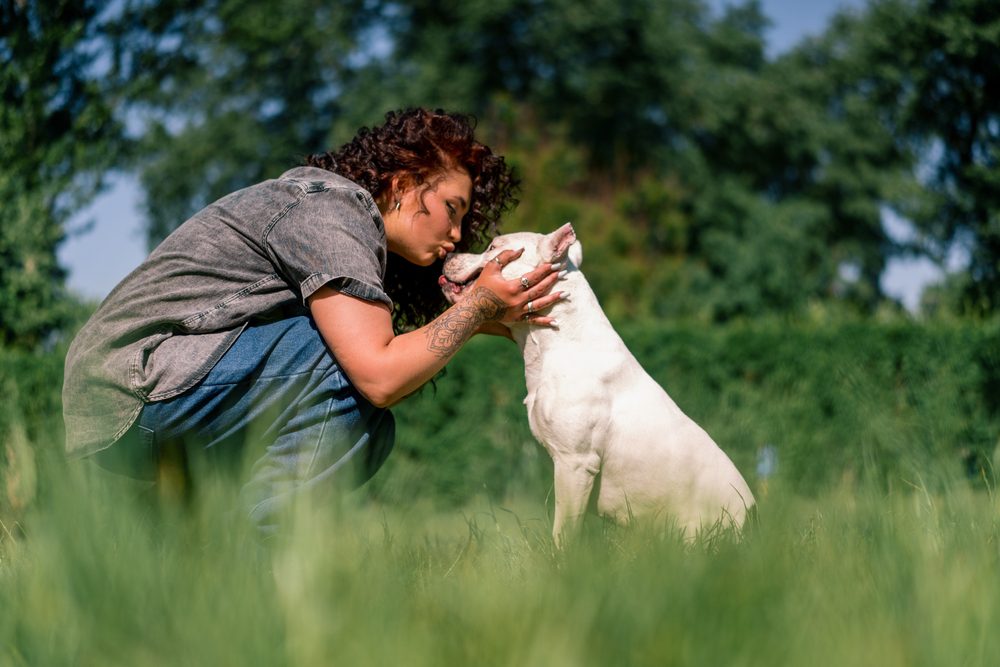 dog receives kiss from woman